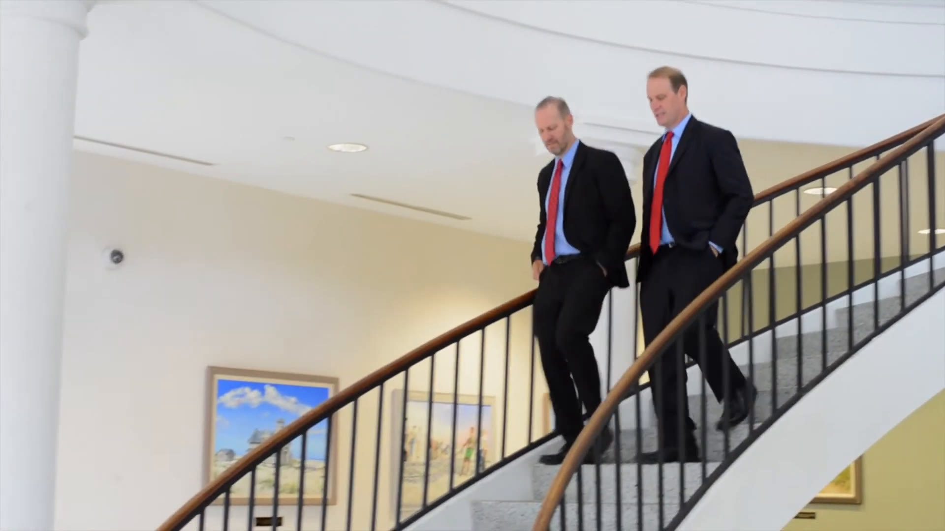 Ben and Jon David walking down a courthouse staircase.