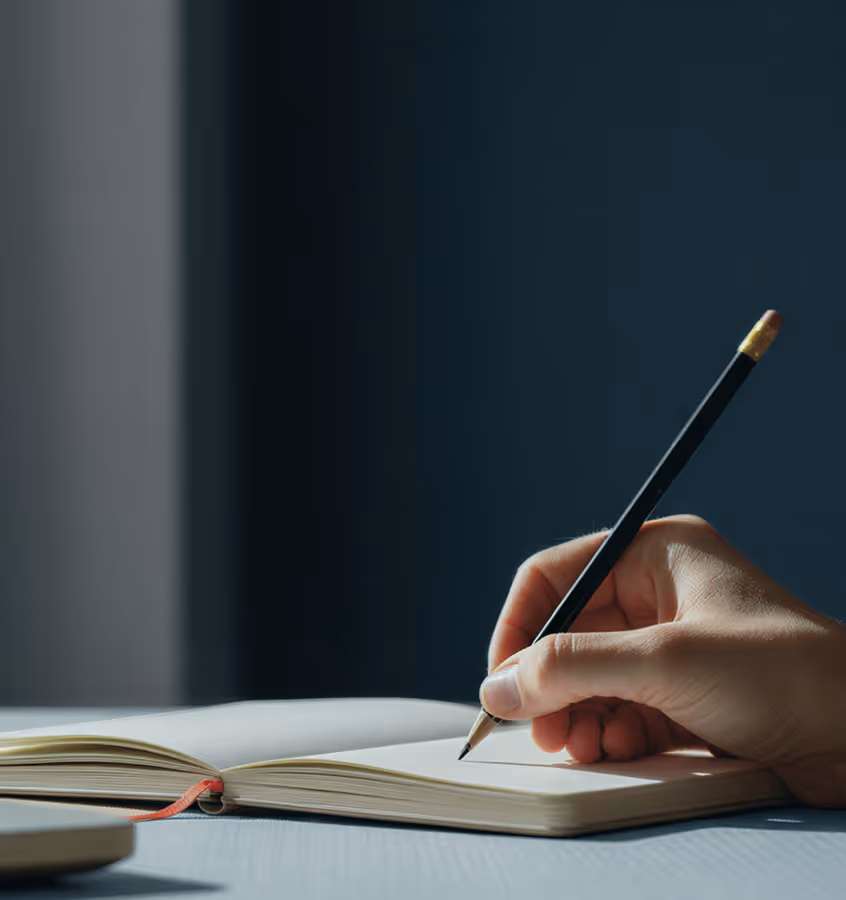 A hand writing in a notebook.